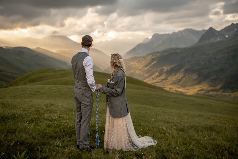 Hochzeitspaar im Gebirge mit Blick zur Sonne