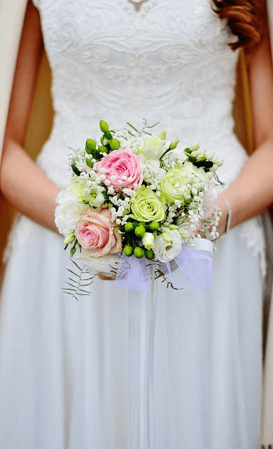 Braut hält einen bunten Brautstrauß in den Händen