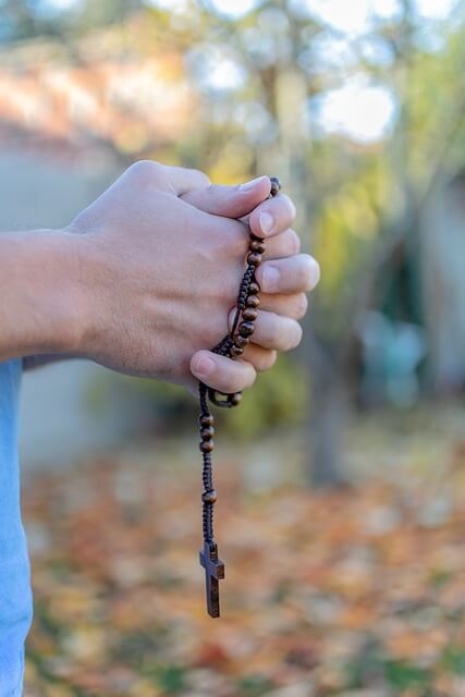 Hände halten eine Gebetskette