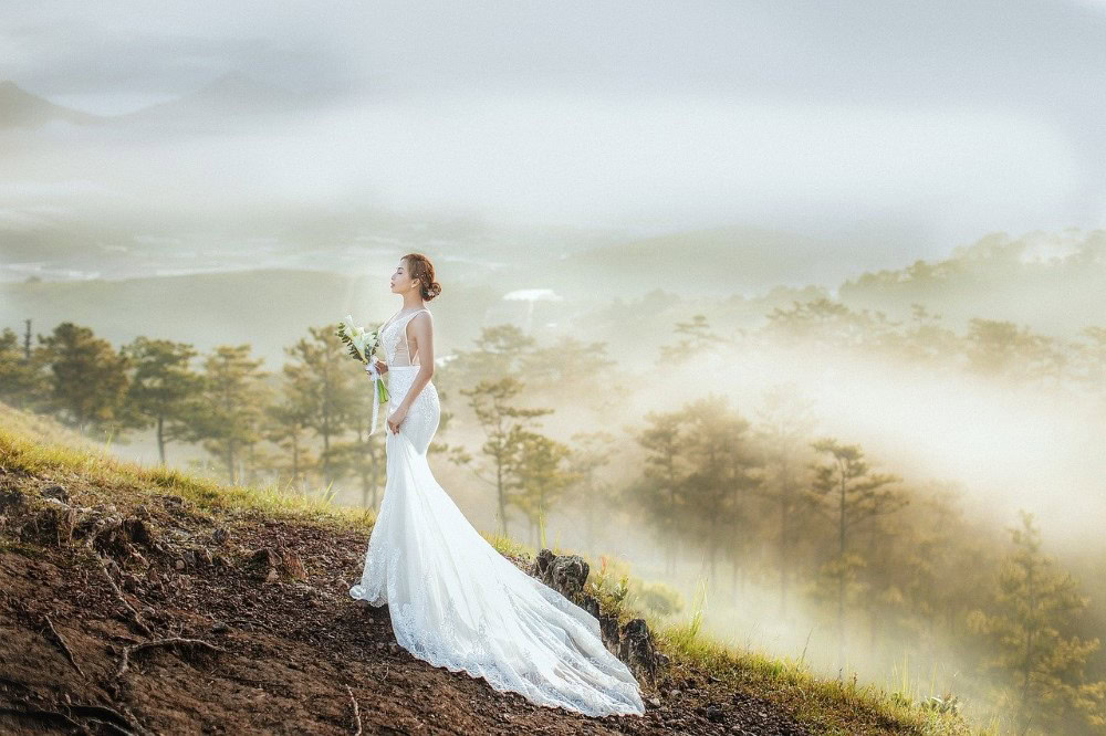 Braut im weißen Kleid auf Berg