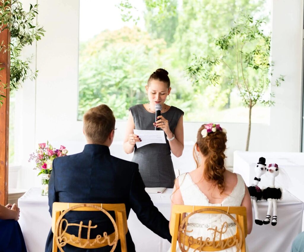 Katharina Paulnsteiner auf einer Freien Trauung. Sie steht vor dem Hochzeitspaar.
