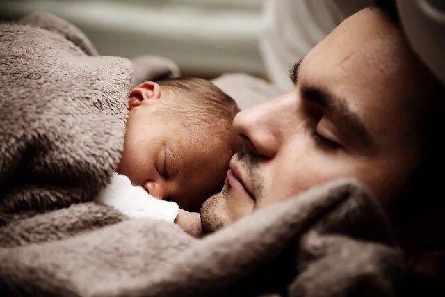 Kinderwillkommensfest - Baby schläft auf Papa
