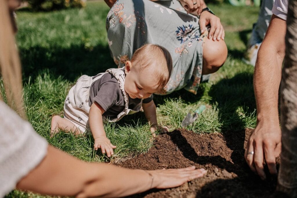 Kinderwillkommensfest Paten - Ein Baby spielt im Garten
