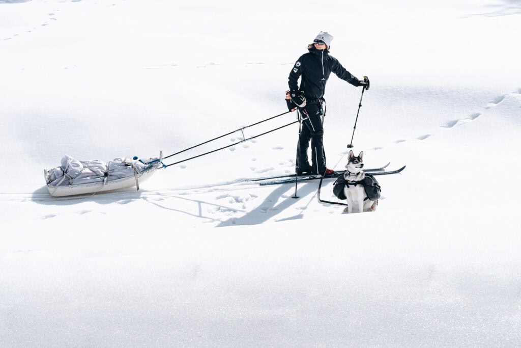 Skifahrer mit Hund in verschneiter Landschaft, Winteraktivität in Österreich, Outdoor-Sport, Schneeschuhwandern, Winterabenteuer, Freie Redner Österreich.