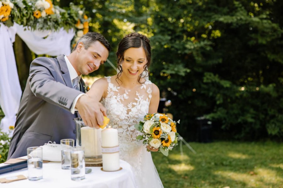 Hochzeitspaar zündet eine Kerze als symbolische Handlung an